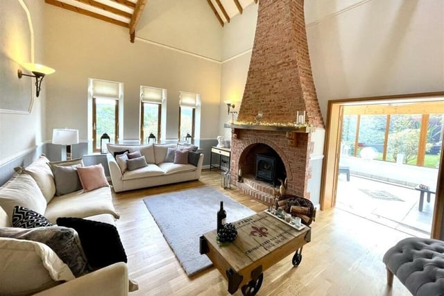 The exposed brick fireplace with stove is a central feature of the beamed living room.