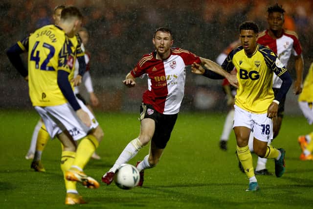 WOKING, ENGLAND - NOVEMBER 16: Jim Kellermann of Woking FC is challenged by Marcus McGuane of Oxford United during the Emirates FA Cup First Round match between Woking FC and Oxford United at The Laithwaite Community Stadium on November 16, 2022 in Woking, England. (Photo by Clive Rose/Getty Images)