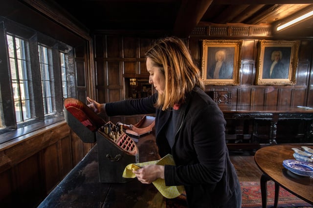 Bozena Klos  cleaning items in the dining room at Shibden Hall