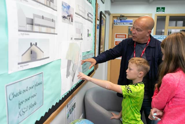 Head teacher Mungo Sheppard shows children the new plans at Ash Green Community Primary School