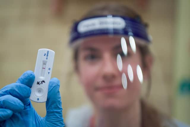 Generic image of a Covid test team member holding up a coronavirus test strip after Covid-19 testing.  Photo by Finnbarr Webster/Getty Images