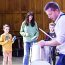 Calderdale Music launch at new centre. Steve Drinkwater leads a samba session. From the left, Seth Harford, 11, mum Emily Harford and Robin Harford, seven.