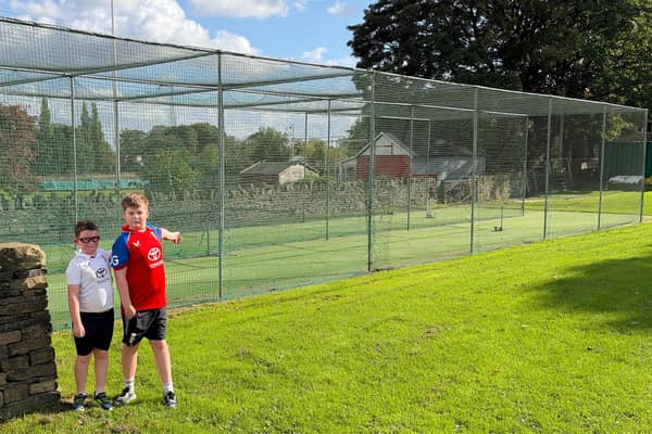 Lightcliffe junior players Dominic and Luke at the club's current nets that need to be replaced.