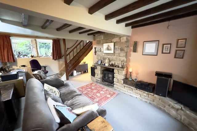 The sitting room with feature stone fireplace and cosy stove.