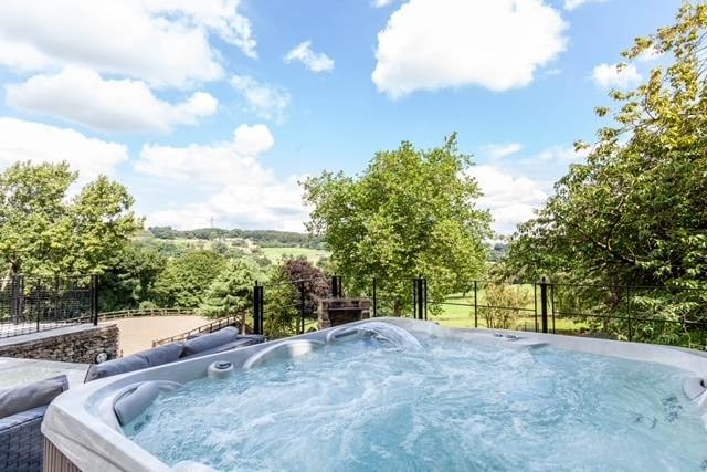 A hot tub area with views of the stables and surrounding scenery. There's also a built-in barbecue and a children's play area.