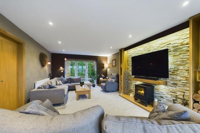 Relaxed lounge space with a central stove and bi-fold doors to the rear garden.