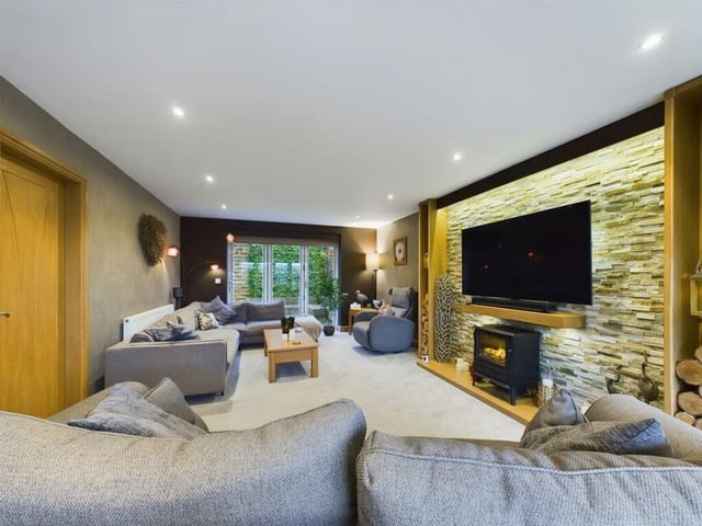Relaxed lounge space with a central stove and bi-fold doors to the rear garden.
