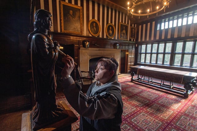 Sarah Todexco cleaning a statue in the main hall at Shibden Hall