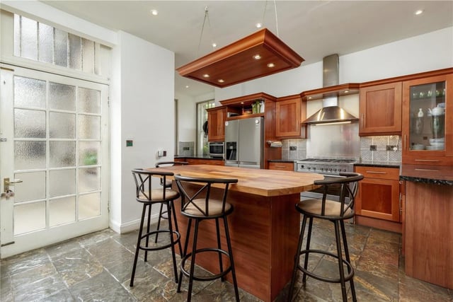 The spacious kitchen is well equipped, featuring a freestanding island and direct access to the private courtyard.
