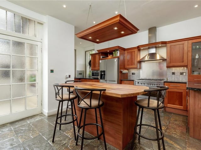 The spacious kitchen is well equipped, featuring a freestanding island and direct access to the private courtyard.