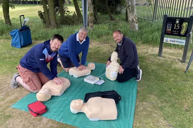 Neil Davidson (centre) with Simon Ferris, and Gary Hulme practicing CPR at the Golf Day