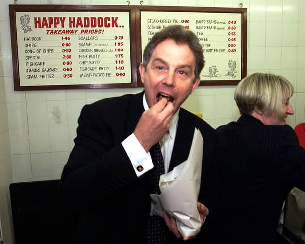 BRIGHOUSE, UNITED KINGDOM:  Prime Minister Tony Blair buys fish and chips at the Happy Haddock restaurant in Brighouse, West Yorkshire 15 May 2001, following a surprise visit to the area during his General Election campaign trail.  POOL (Photo credit should read HARRY PAGE/AFP via Getty Images)