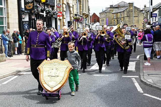 B&R's Flugel player Mike Eccles, ably assisted by Christopher, son of Trombonist Steve Lomas, lead the band with the Open Trophy along Bethel Street. Picture: Gordon Ratcliffe