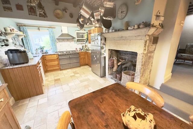 The kitchen with diner has fitted units and a large, central stone feature fireplace.