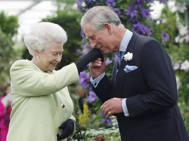 Queen Elizabeth II presents Prince Charles, Prince of Wales with the Royal Horticultural Society's Victoria Medal of Honour during a visit to the Chelsea Flower Show. (Pic credit: Sang Tan / WPA Pool / Getty Images)