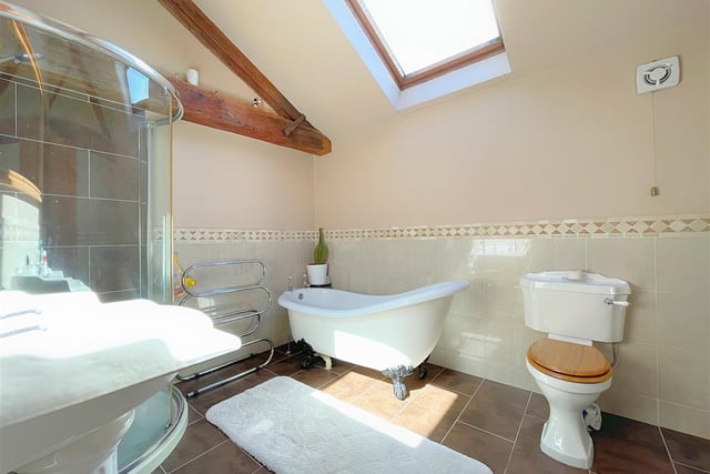 A free standing slipper bath, and a walk-in shower cubicle feature within this bathroom.
