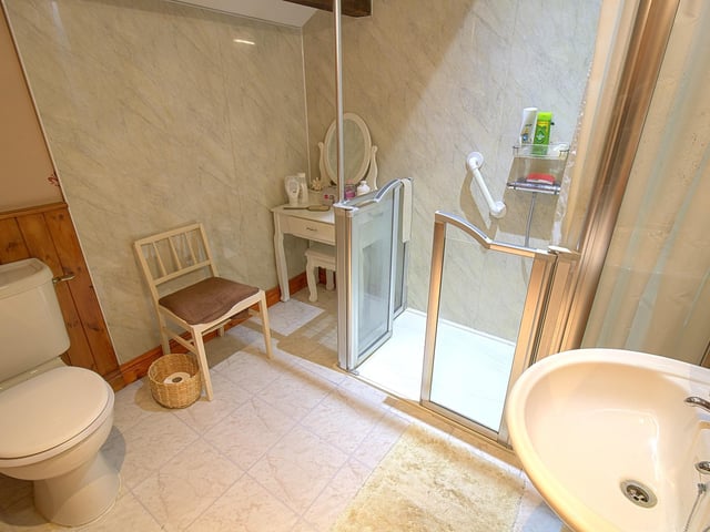 A walk-in shower with fitted seat forms part of the shower room suite.