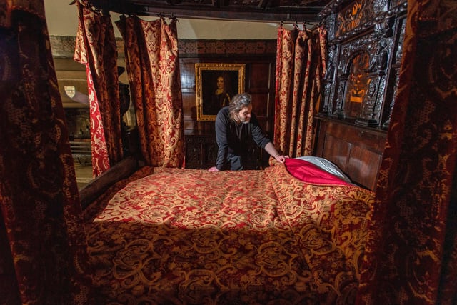 Chris Southwell making the bed in the red bedroom at Shibden Hall
