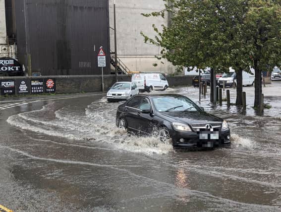 Cars drive having to drive through water near Rokt in Brighouse. Photo by Steven Lord