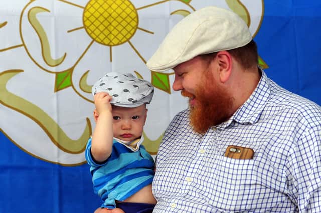 Happy Yorkshire Day - Father and son celebrate the day at Kirkgate Market, Leeds, sporting traditional flat caps