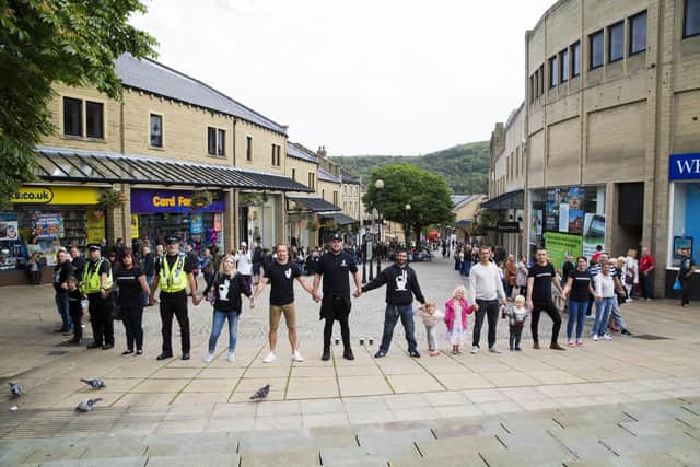 Luke Ambler, centre, and friends raise awareness for the Calderdale founded organisation Andy's Man Club by holding hands round The Woolshops Shopping Centre, Halifax, pictured in 2016.