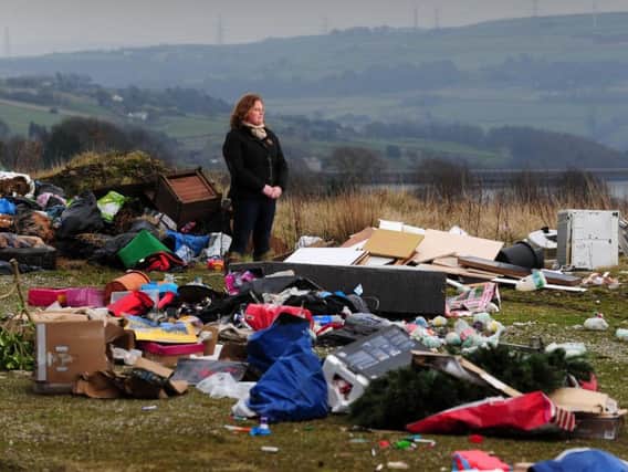 Rachel Hallos pictured amongst the mess left by flytippers alongside Beeston Hall Farm in Ripponden.