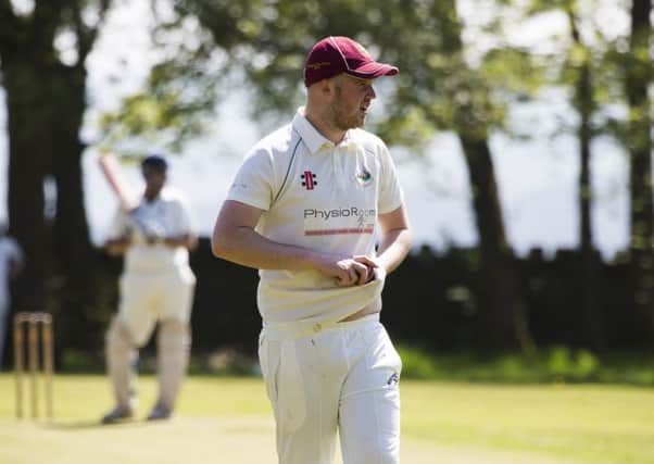 Cricket - Old Town v Luddendenfoot. Charlie Holt-Conway polishes the ball for Luddendenfoot.