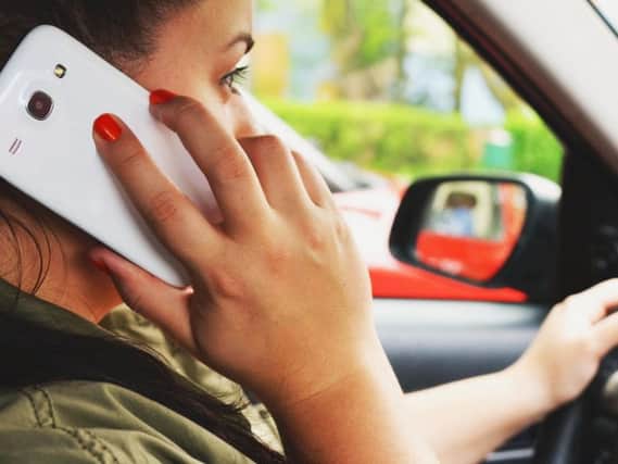 All too common a sight: Using a mobile phone at the wheel can cause fatal errors of judgement.
