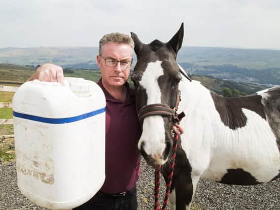 Donal OHanlon at his home in Todmorden, with Spirit the horse and one of the vital water containers