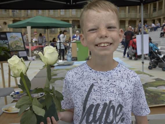 Archie Foster, aged nine, poses with a Yorkshire rose.