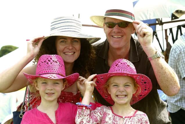 2009: 
Chris and David Wilkinson with daughters Jessica (six) and Georgina (five) try on sun hats