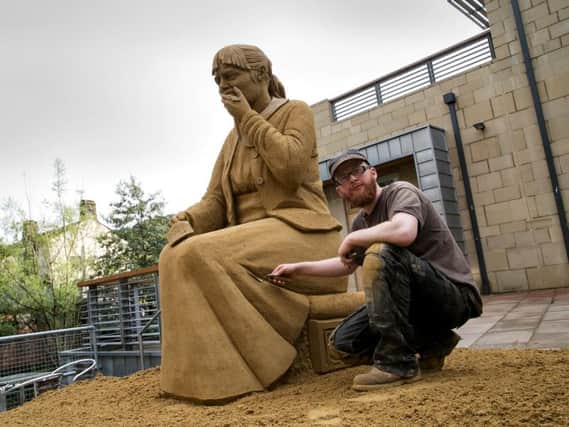 Jamie Wardley from Sand in Your Eye, with the Loss is Eternal sand sculpture outside Hebden Bridge Town Hall.