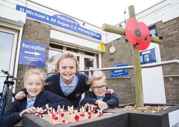 Poppy display outside St Michael & All Angels CE Primary School, Shelf. from the left, Stella McNeill, eight, Evie Rice, nine, and Phoebe Brighouse-Johnson, seven.