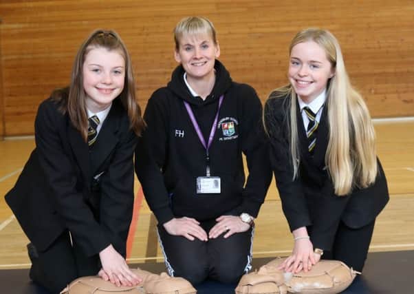 Life-saving skill: Frances Hammond teaches CPR to pupils Katie Brook, right, and Megan Hodson.