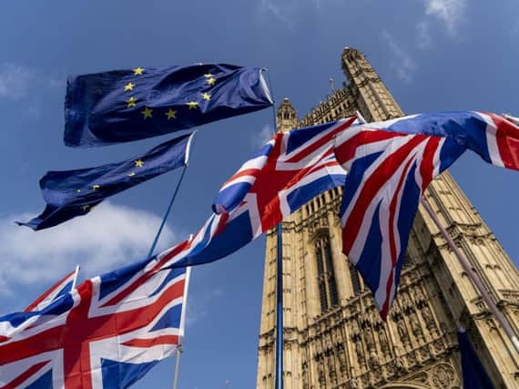 Union and EU fags flutter outside the Houses of Parliament in Westminster, London (Photo credit should read NIKLAS HALLE'N/AFP/Getty Images)
