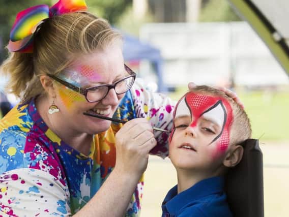 Seth Paniczew, four, has his face painted by Ali Lee.