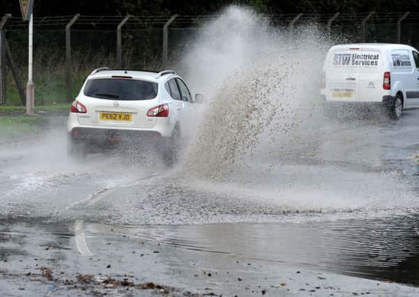 car splashes through flooded road