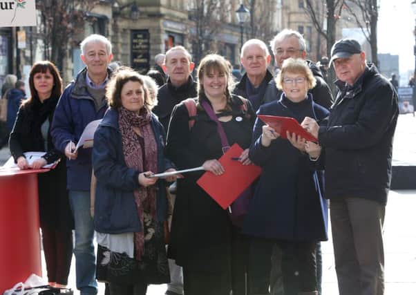 Eric Aked, right, signs a petition to save the Calderdale Royal Hospital A&E department, with Halifax MP Linda Riordan and Labour councillors and supporters.
