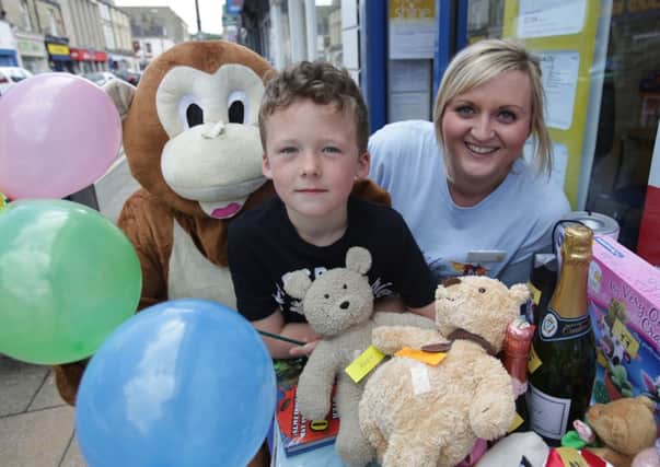 Family Fun Day for Overgate Hospice at Co-operative Travel. Commercial Street, Brighouse. Luke Tyrell, aged seven with Laura Young and Mike the Monkey.