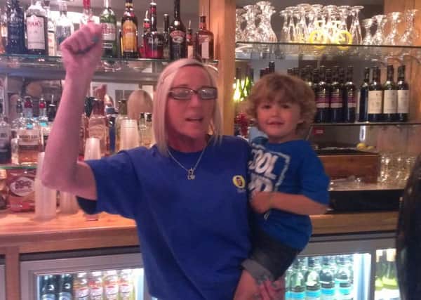Barmaid Julie Asquith and her two-year-old grandson Harvey get ready for Le Tour at the Dusty Miller, Mytholmroyd
