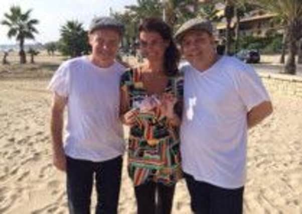 Dan Coll, left and Dan Carey, right, with snooker and pool referee Michaela Tabb on a beach in Salou, Spain, as she helps the actors raise some cash