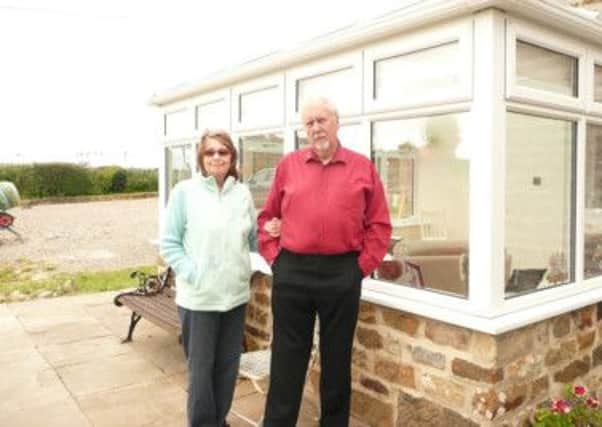 Geoff and Reta McKinley in front of their conservatory (s)