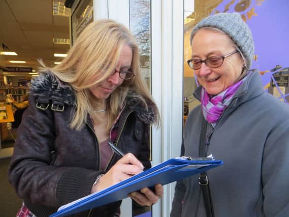 Knaresborough Library user Karen Watson signs the petition to stop the library becoming a skeleton service, with petition volunteer Jean Longstaff.