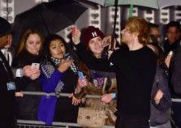 Ed Sheeran takes selfies with fans at the BBC Music Awards at Earl's Court, London.