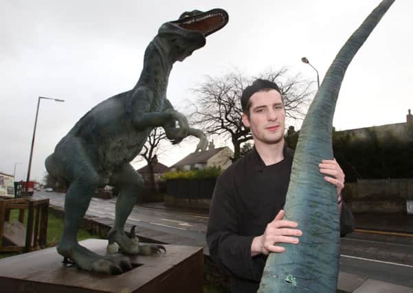 Josh Jeffrey, chef at Harry's Carvery, Wyke, with one of the vandalised dinosaurs.