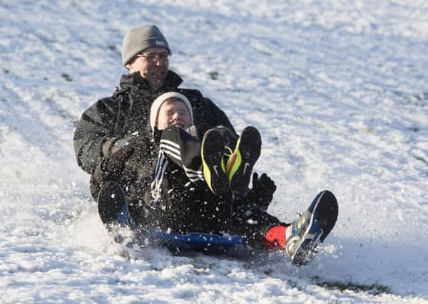 Sledging in the snow at Shibden Park, Halifax. Oliver Ridsdale, 11, and dad Andrew Ridsdale.