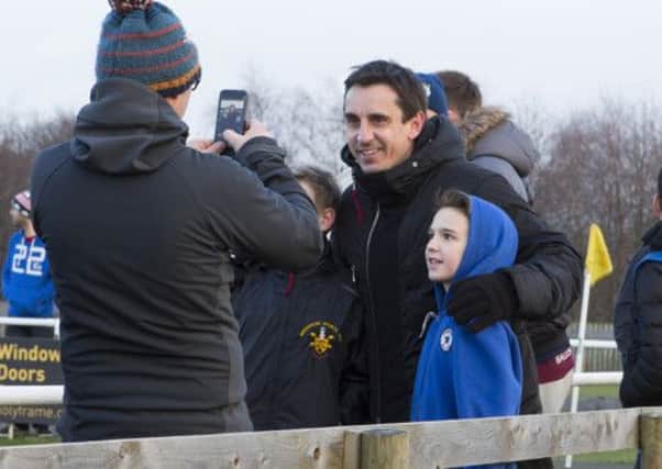 Gary Neville poses with young fans at Brighouse Town FC, during the visit from Salford City FC