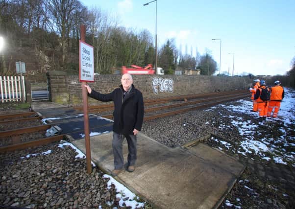 Councillor David Kirton stood at the side of the pedestrian level crossing which goes over the rail track at Lower Brear, Hipperholme.