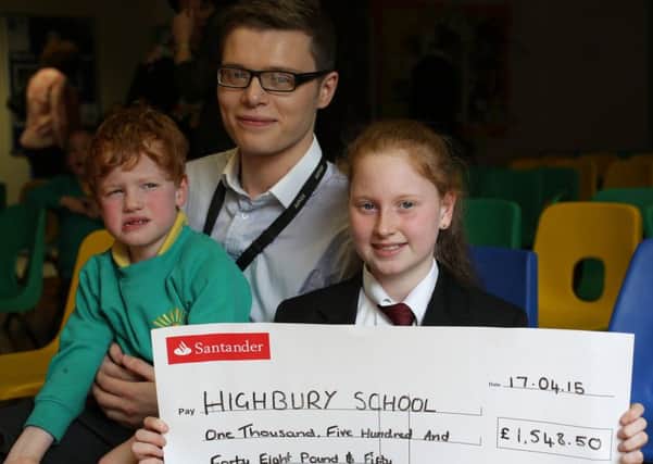 Eleven-year-old Zaina  Lane presents £1,548.50 to her brother Austin, aged four, and his teacher Richie Johnson at Highbury School. Rastrick.