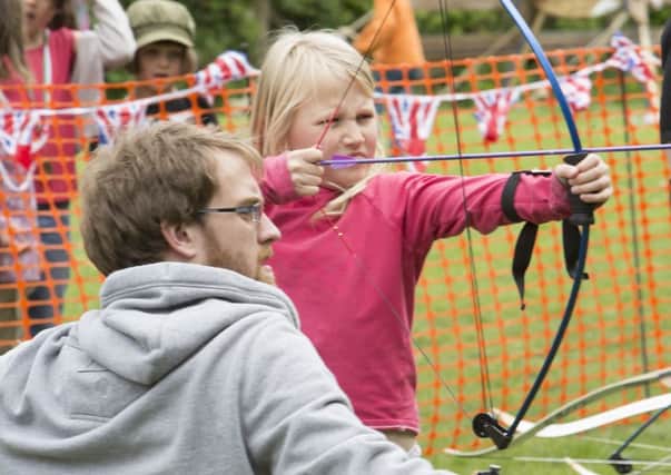 White Rose Archers and Hebden Bridge Cricket Club family fun day and Nepal fundraiser. Dave King shows Anna Mason, eight, how it's done.